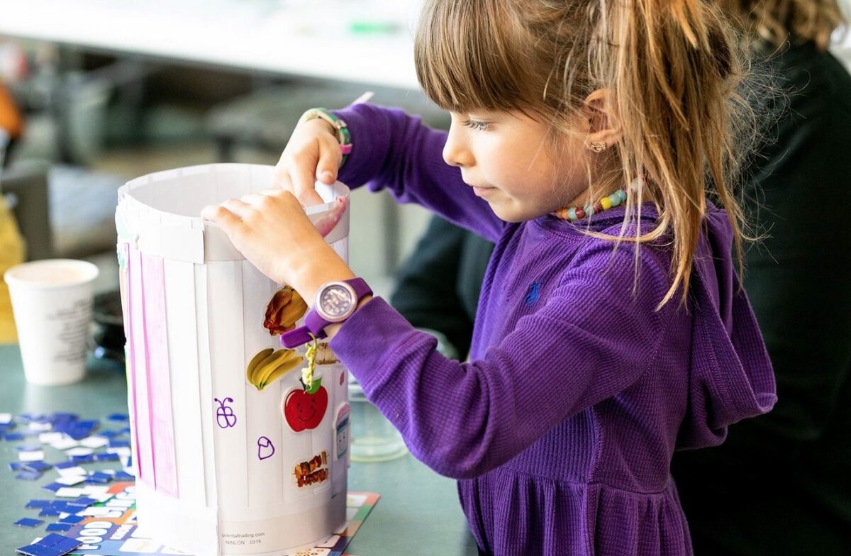 Child works on a craft activity at the Eat/Play/Give brunch