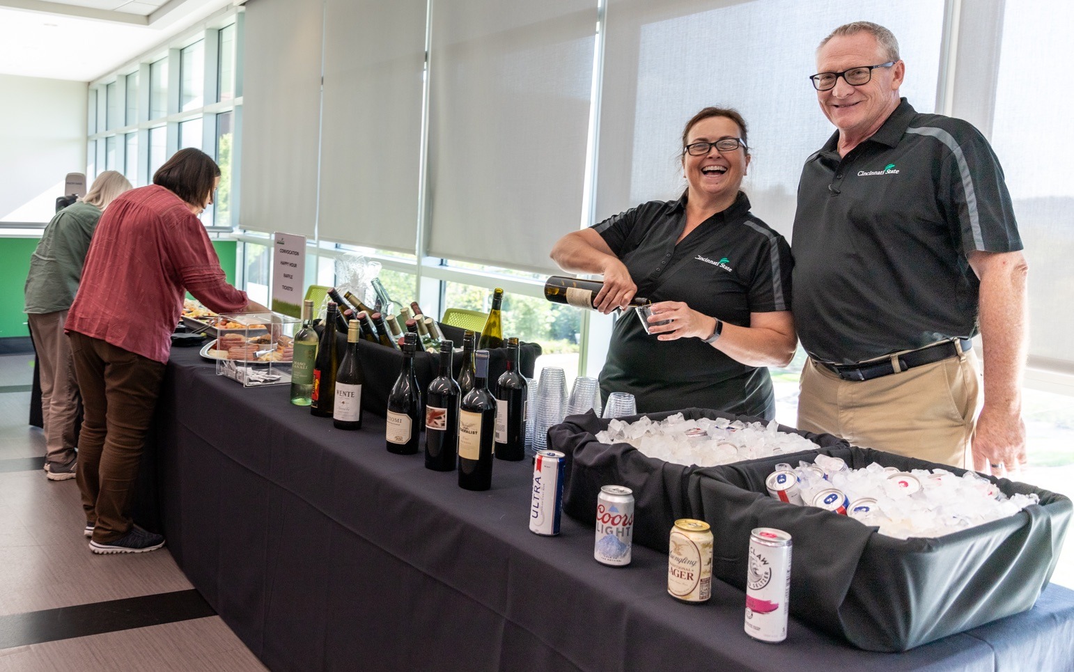 Jackie Norton and Tom Hale greet employees at Convocation 2023 Happy Hour