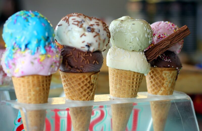 four ice cream cones, each with two scoops of ice cream of various colors