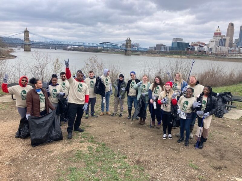 Environmental Engineering Technology students in front of the Cincinnati skyline while assisting with the Ohio River Sweep Cleanup