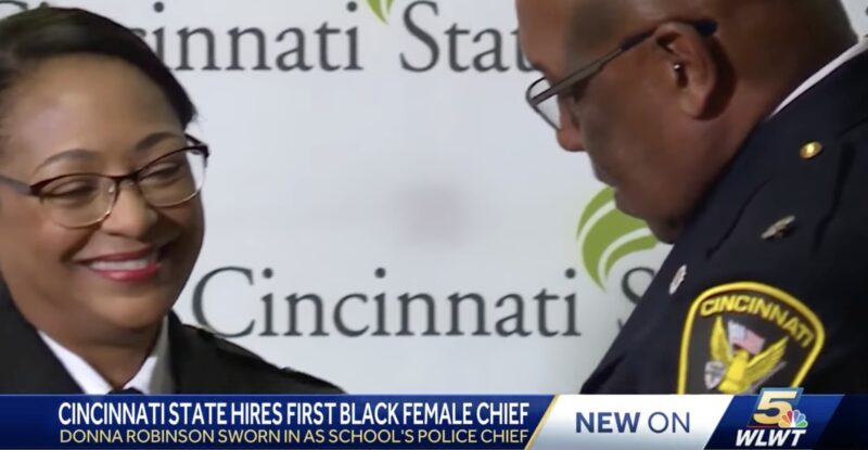 Chief Donna Robinson receives her badge from Eliot isaac, Chief of Police at UC and former City of Cincinnati Chief of Police